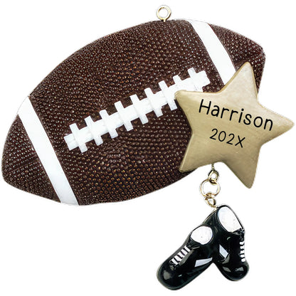 A personalized Christmas ornament designed to look like a football with a star, featuring the text 'Harrison Year' and a pair of shoe prints in black.