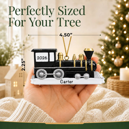 Size guide: the personalized locomotive train christmas ornament is 4.50 in wide by 2.25 in tall, shown in hand