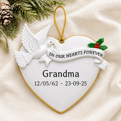 Personalized Memorial Dove Heart christmas ornament laid on a soft white knit blanket