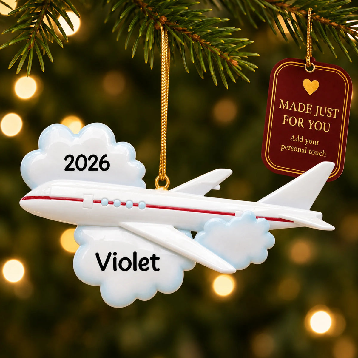 Flying airplane travel christmas ornament hanging on a lit Christmas tree with a Made Just For You gift tag