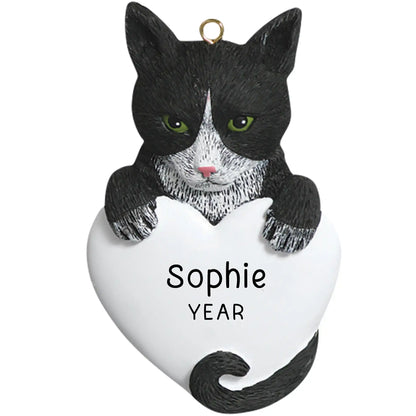 Personalized Christmas ornament featuring a black and white tuxedo cat with green eyes, holding a large blank white heart ready for custom pet name engraving.