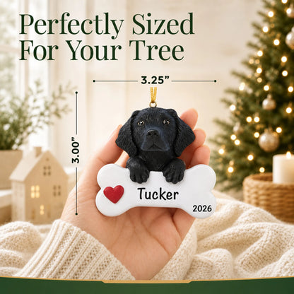 Hand holding the personalized black Lab Christmas ornament to show its 3.25 by 3 inch size
