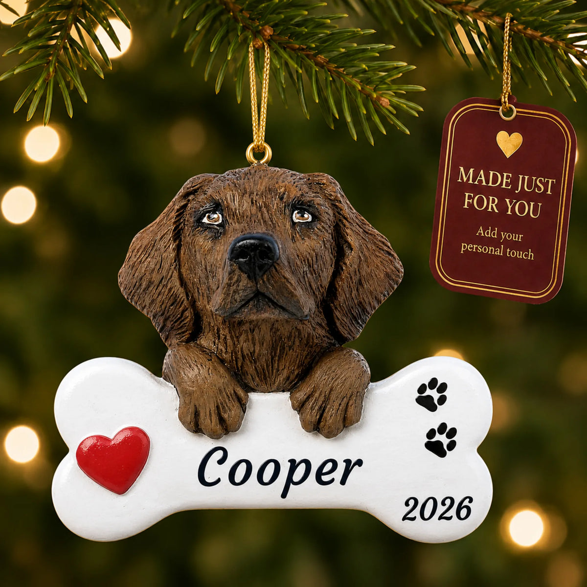 Chocolate Lab Dog Bone christmas ornament hanging on a lit Christmas tree with a Made Just For You gift tag