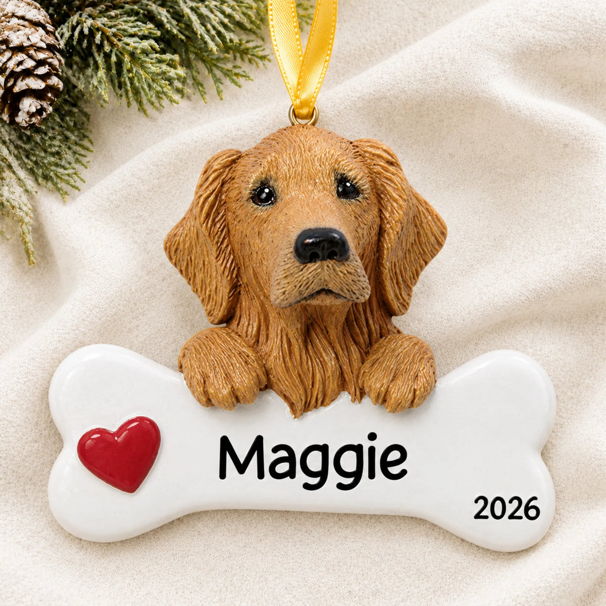 Personalized golden retriever dog bone Christmas ornament resting on a soft white blanket with pine and pinecones