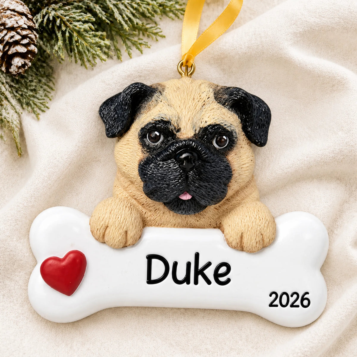 Personalized pug dog bone Christmas ornament resting on a soft white blanket with pine and pinecones