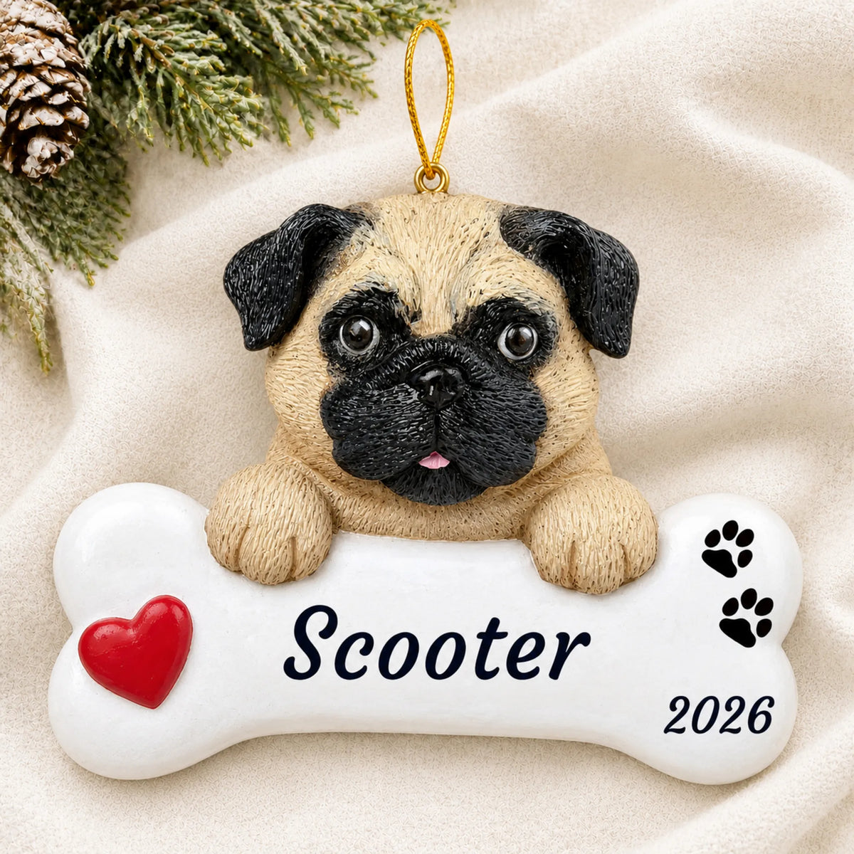 Personalized pug dog bone Christmas ornament resting on a soft white blanket with pine and pinecones