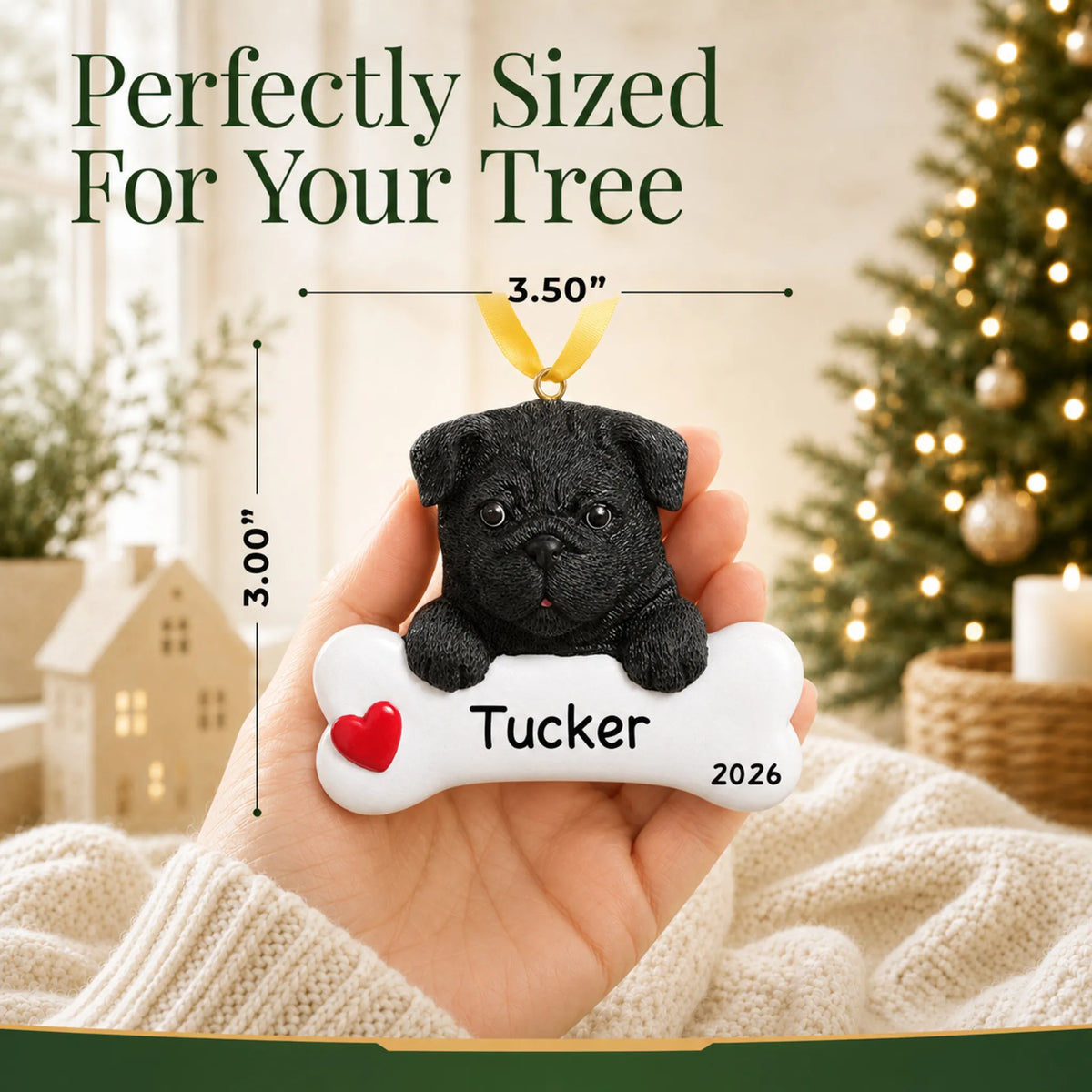 Hand holding the personalized black pug Christmas ornament to show its 3.50 inch width