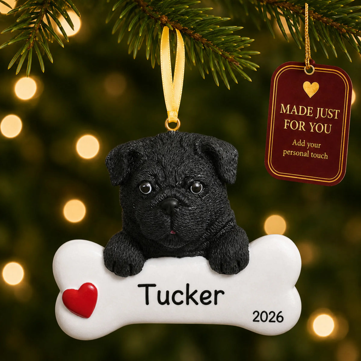 Personalized black pug Christmas ornament hanging on a lit tree beside a Made Just For You tag