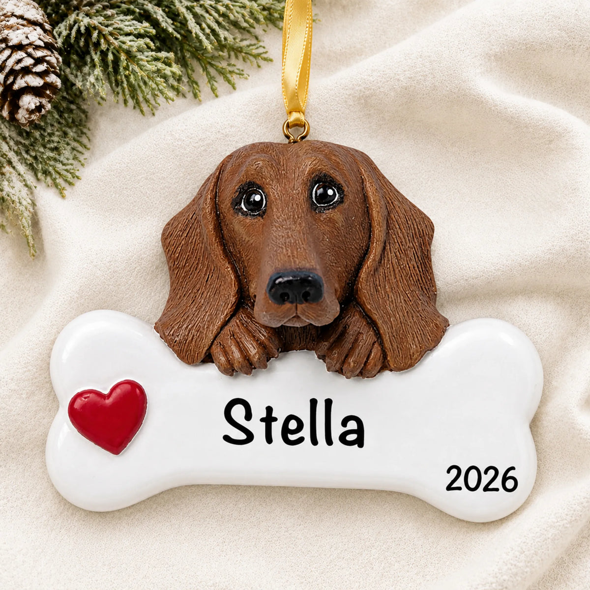 Personalized dachshund dog bone Christmas ornament resting on a soft white blanket with pine and pinecones