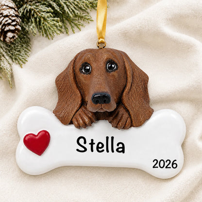Personalized dachshund dog bone Christmas ornament resting on a soft white blanket with pine and pinecones