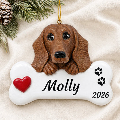 Personalized Dachshund Dog Bone christmas ornament laid on a soft white knit blanket