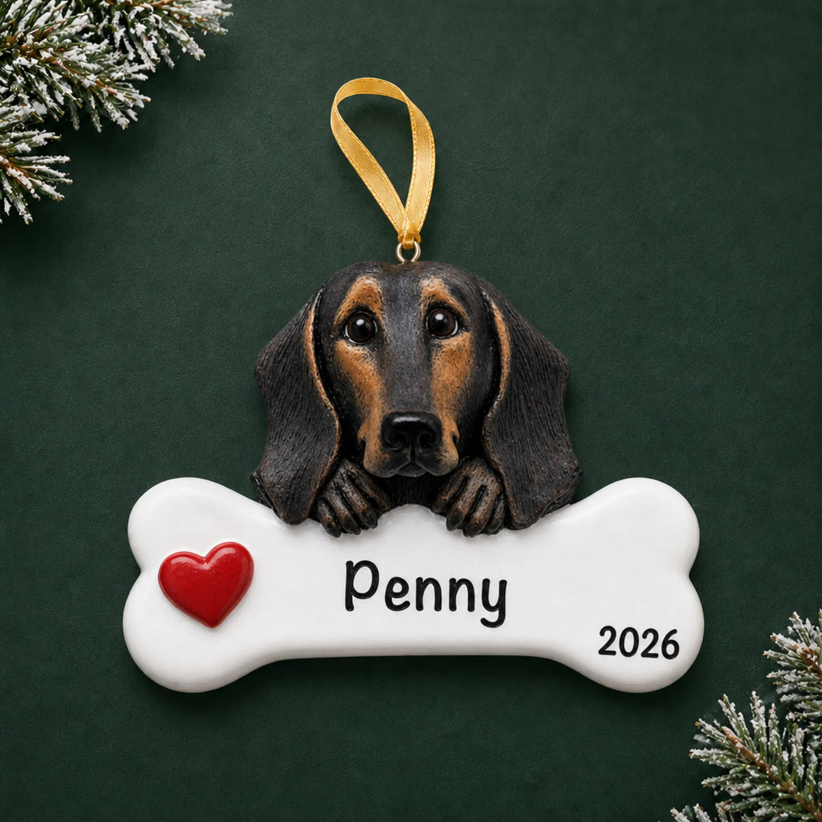 Personalized black and tan dachshund dog bone Christmas ornament, engraved with a name and year, on a green holiday backdrop