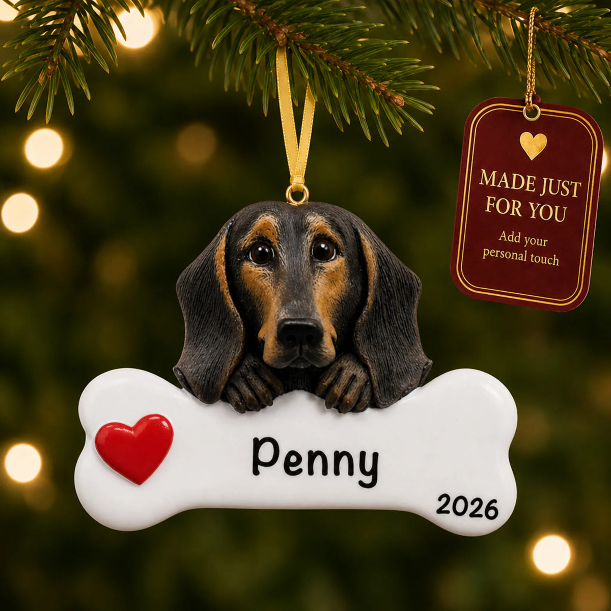 Personalized black and tan dachshund Christmas ornament hanging on a lit tree beside a Made Just For You tag