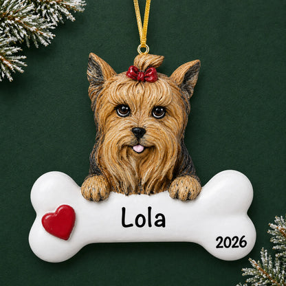 Personalized Yorkie dog bone Christmas ornament, engraved with a name and year, on a green holiday backdrop