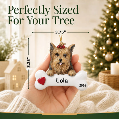 Hand holding the personalized Yorkie Christmas ornament to show its 3.75 inch width