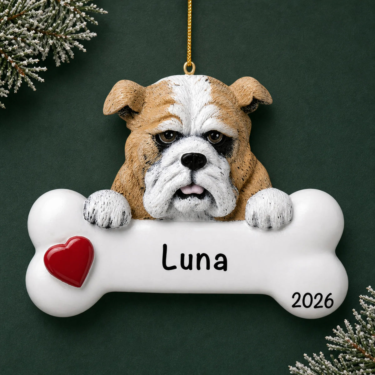 Personalized bulldog dog bone Christmas ornament, engraved with a name and year, on a green holiday backdrop