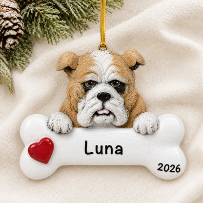 Personalized bulldog dog bone Christmas ornament resting on a soft white blanket with pine and pinecones