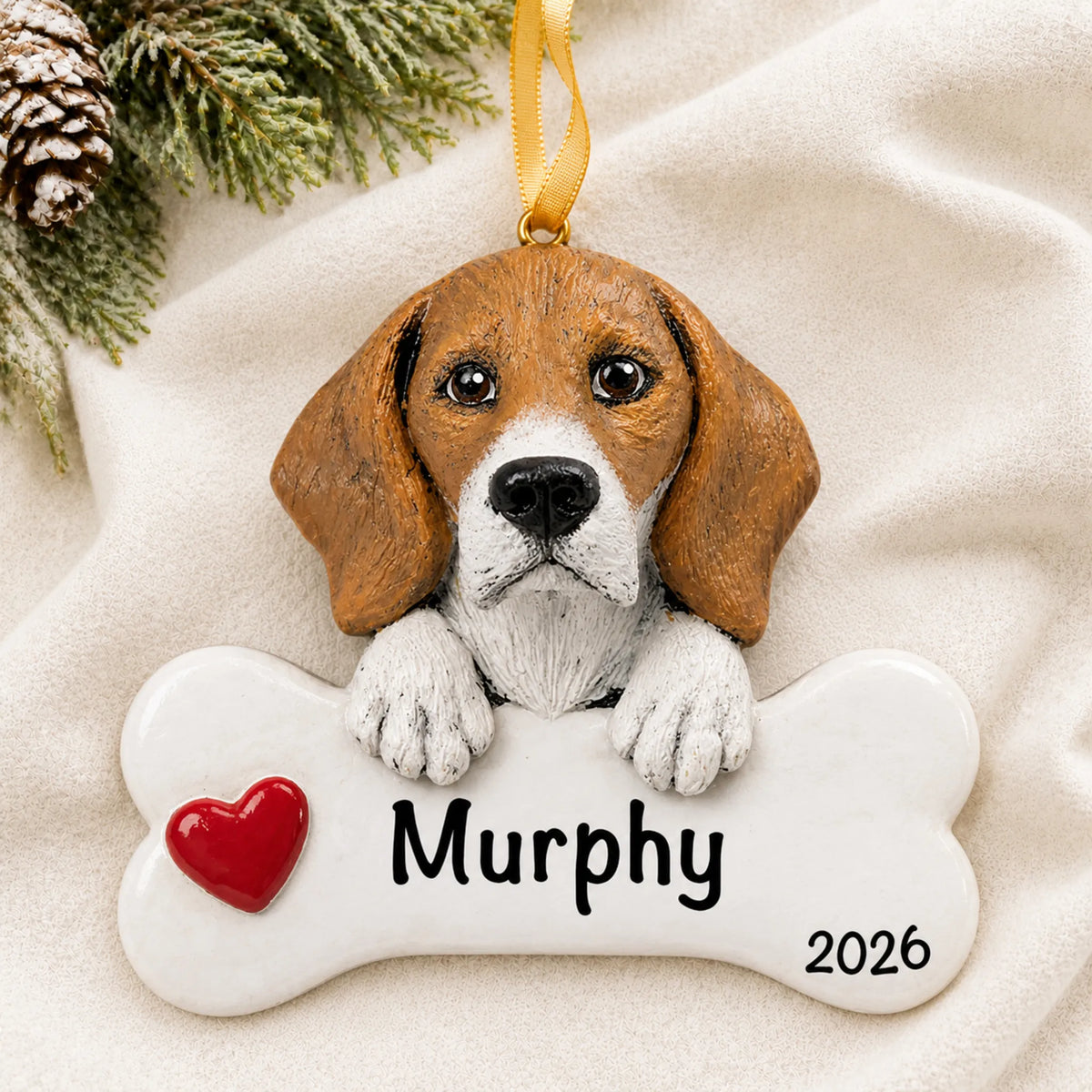 Personalized beagle dog bone Christmas ornament resting on a soft white blanket with pine and pinecones