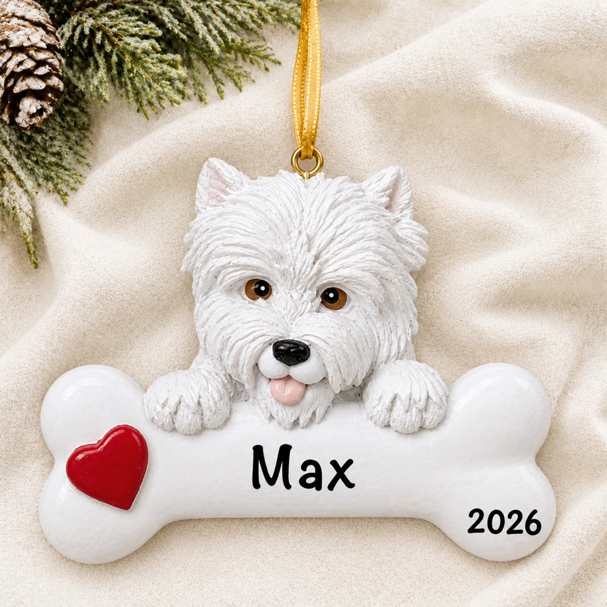 Personalized Westie dog bone Christmas ornament resting on a soft white blanket with pine and pinecones