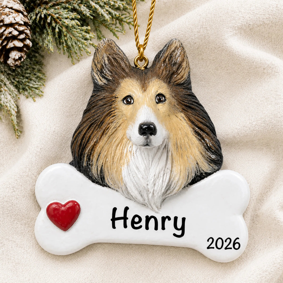 Personalized collie dog bone Christmas ornament resting on a soft white blanket with pine and pinecones