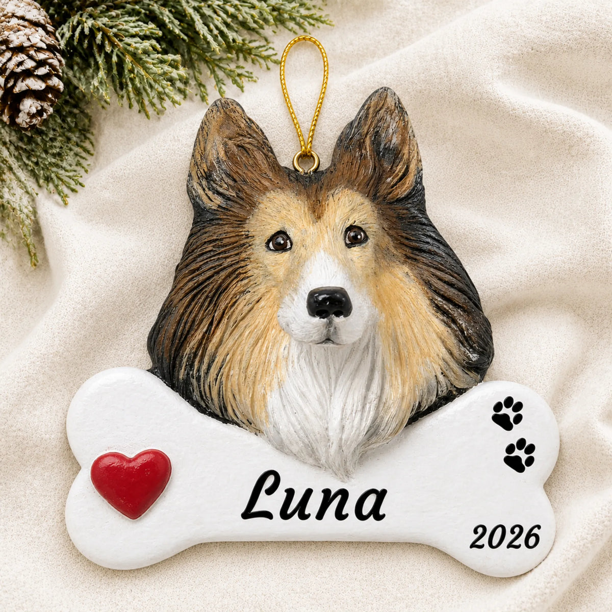 Personalized Collie Dog Bone christmas ornament laid on a soft white knit blanket