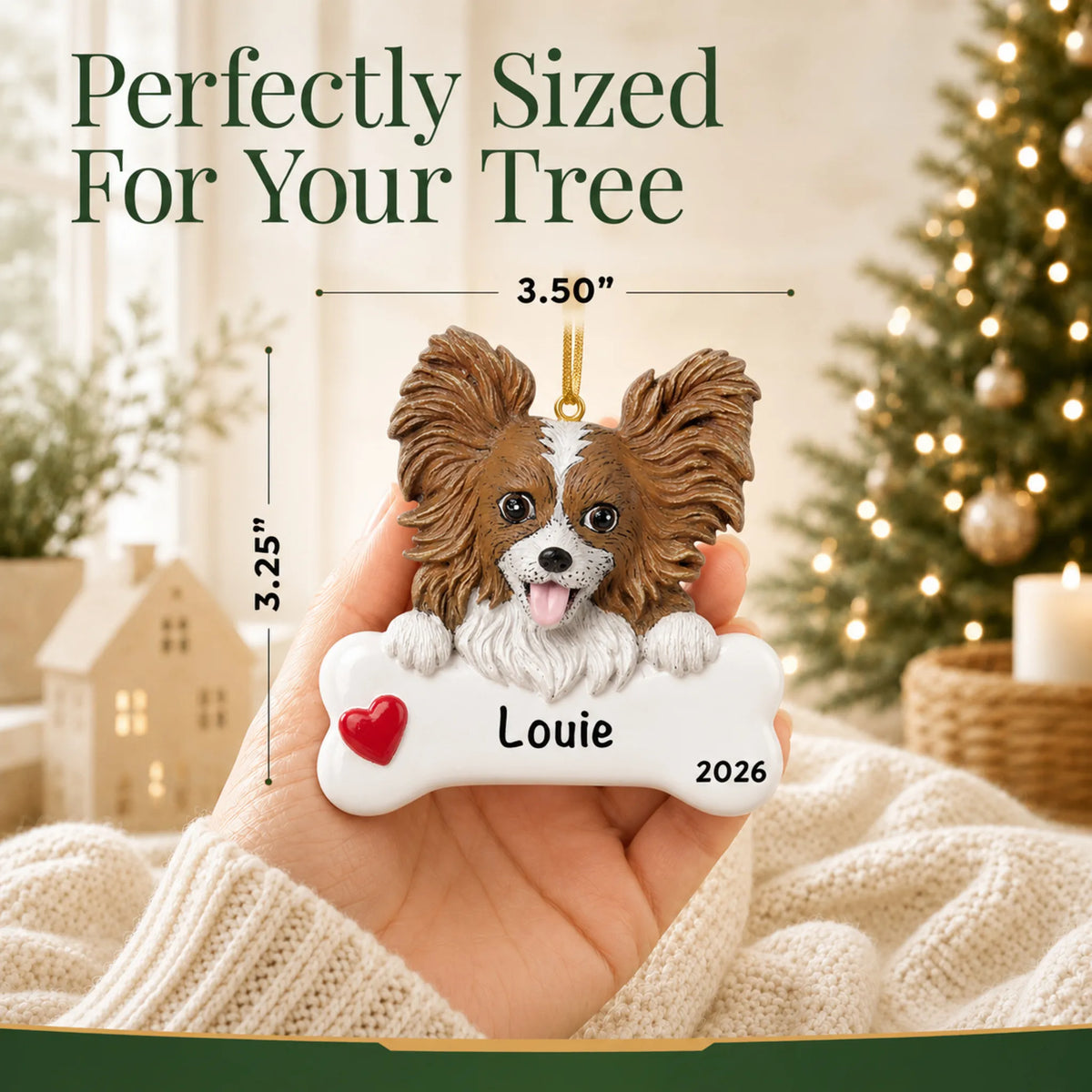 Hand holding the personalized papillon Christmas ornament to show its 3.50 inch width
