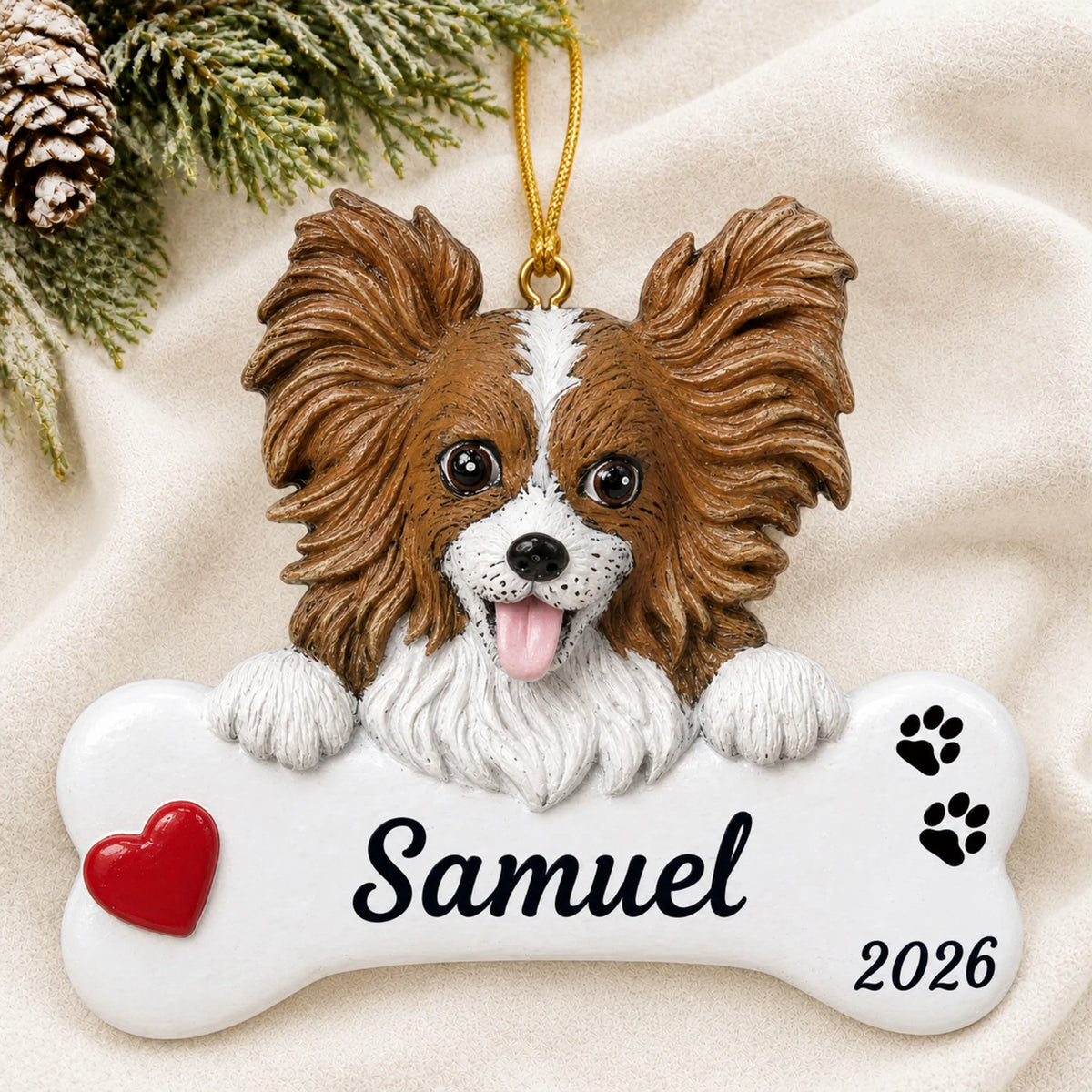 Personalized Papillon Dog Bone christmas ornament laid on a soft white knit blanket