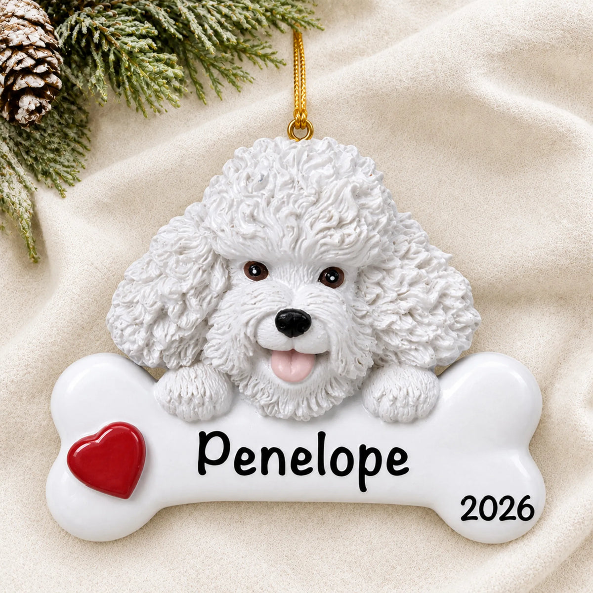 Personalized Bichon Frise dog bone Christmas ornament resting on a soft white blanket with pine and pinecones