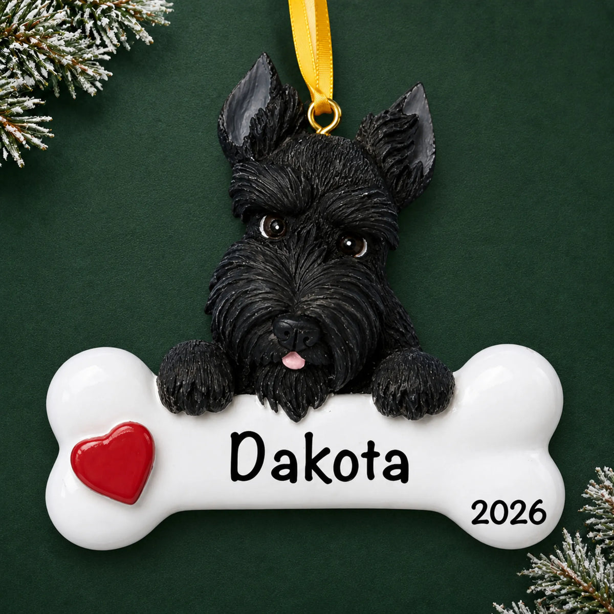 Personalized Scottie dog bone Christmas ornament, engraved with a name and year, on a green holiday backdrop