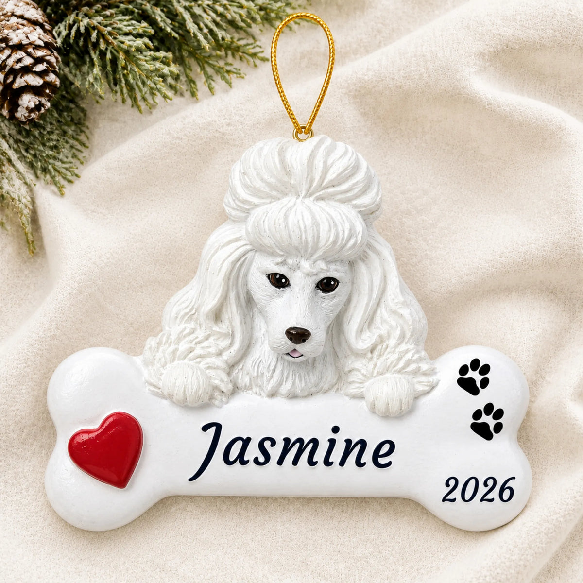 Personalized White Poodle Dog Bone christmas ornament laid on a soft white knit blanket