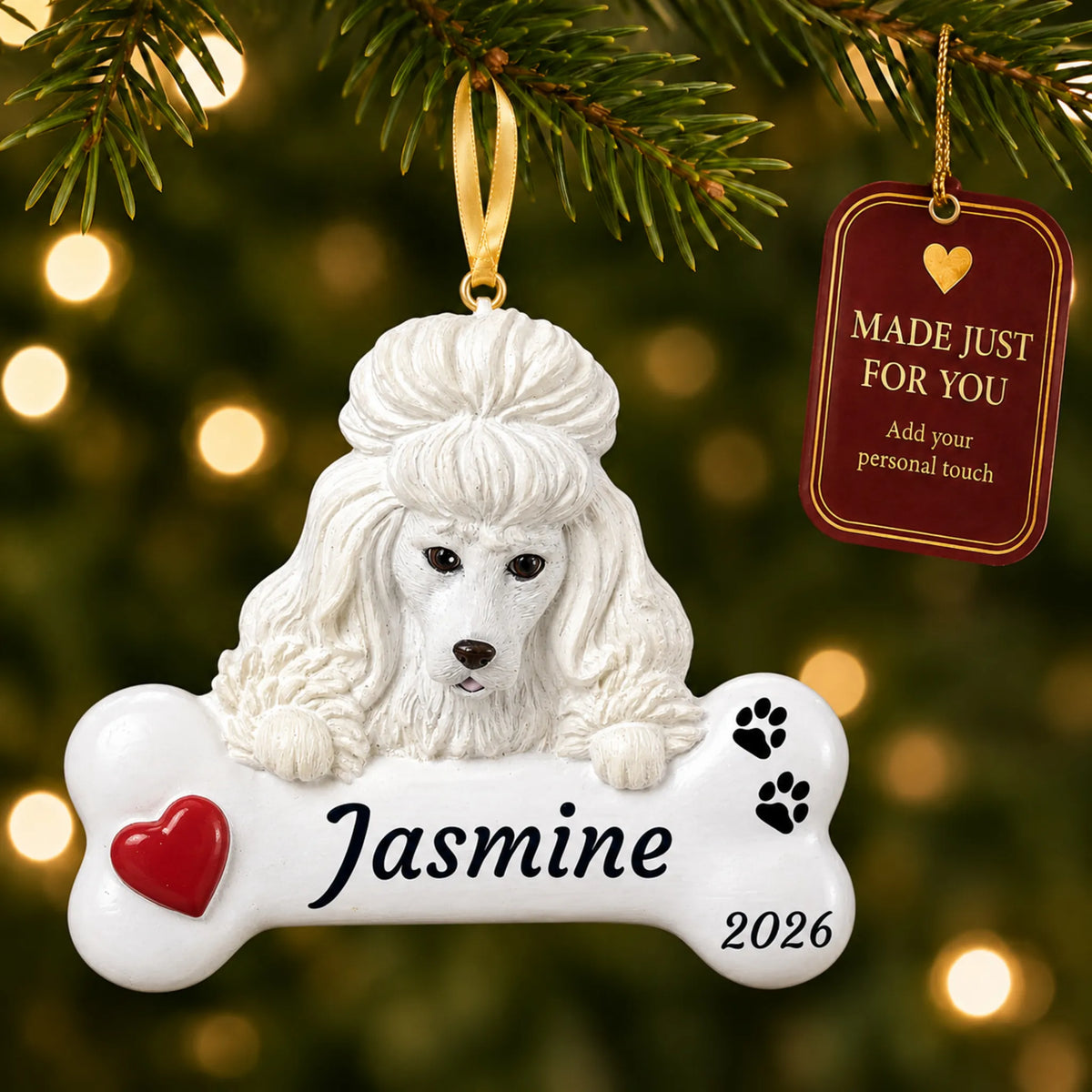 White Poodle Dog Bone christmas ornament hanging on a lit Christmas tree with a Made Just For You gift tag