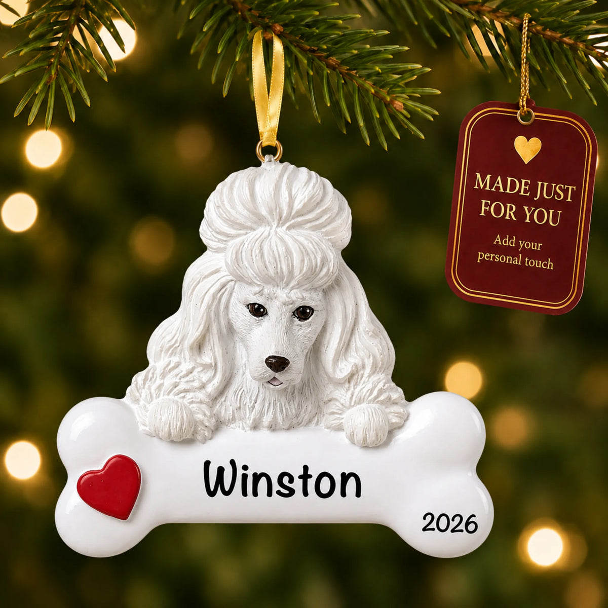 Personalized white poodle Christmas ornament hanging on a lit tree beside a Made Just For You tag