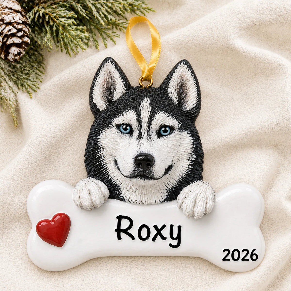 Personalized Siberian husky dog bone Christmas ornament resting on a soft white blanket with pine and pinecones