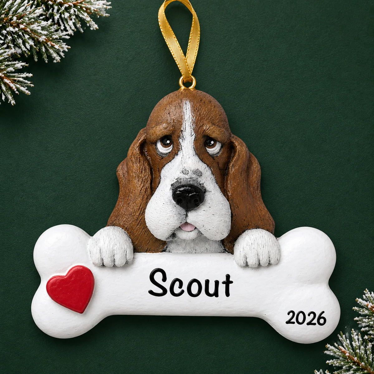 Personalized basset hound dog bone Christmas ornament, engraved with a name and year, on a green holiday backdrop