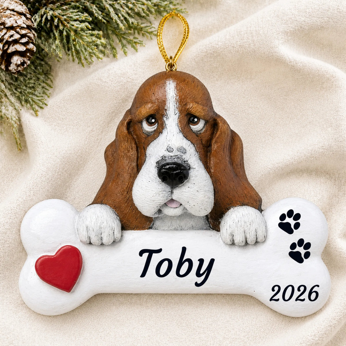Personalized Basset Hound Dog Bone christmas ornament laid on a soft white knit blanket