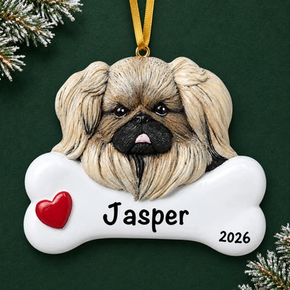 Personalized Pekingese dog bone Christmas ornament, engraved with a name and year, on a green holiday backdrop