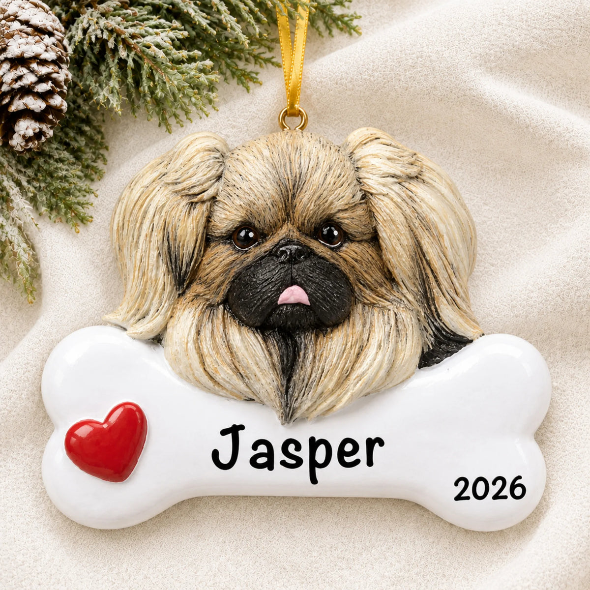 Personalized Pekingese dog bone Christmas ornament resting on a soft white blanket with pine and pinecones