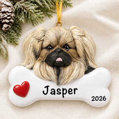 Personalized Pekingese dog bone Christmas ornament resting on a soft white blanket with pine and pinecones