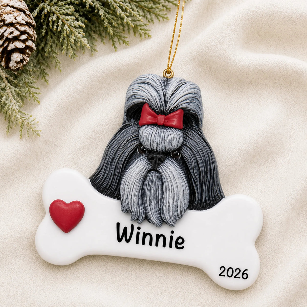 Personalized Shih Tzu dog bone Christmas ornament resting on a soft white blanket with pine and pinecones
