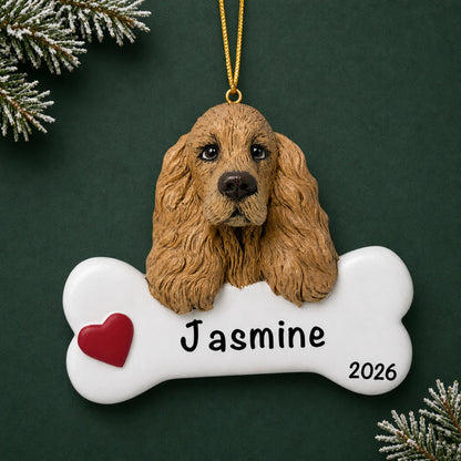 Personalized cocker spaniel dog bone Christmas ornament, engraved with a name and year, on a green holiday backdrop