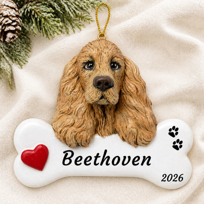 Personalized Cocker Spaniel Dog Bone christmas ornament laid on a soft white knit blanket