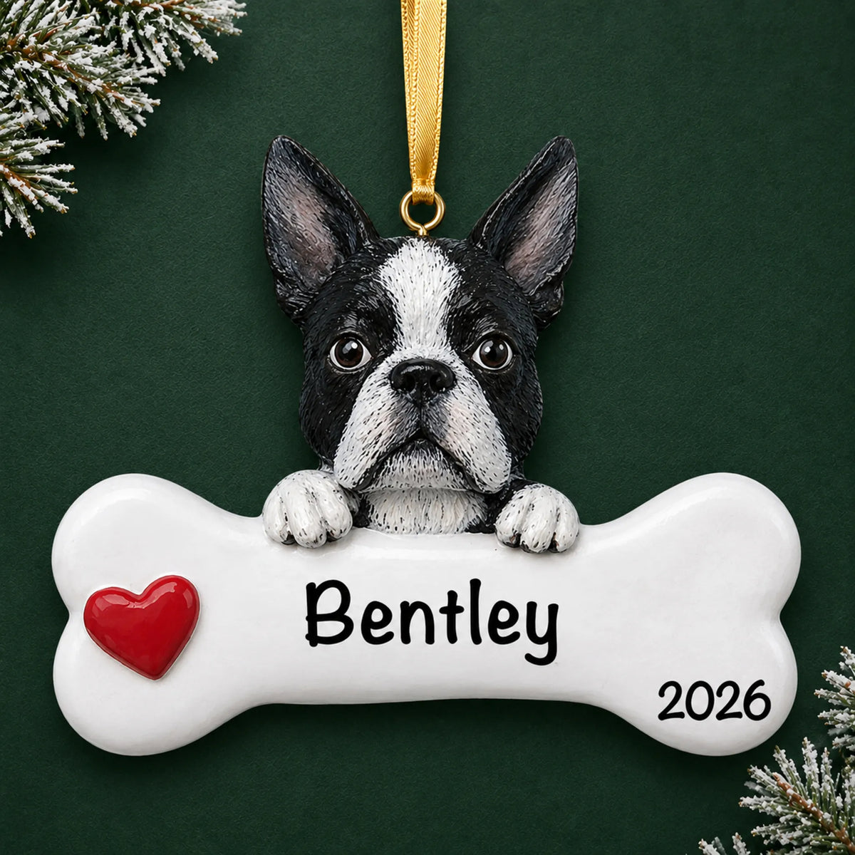 Personalized Boston terrier dog bone Christmas ornament, engraved with a name and year, on a green holiday backdrop