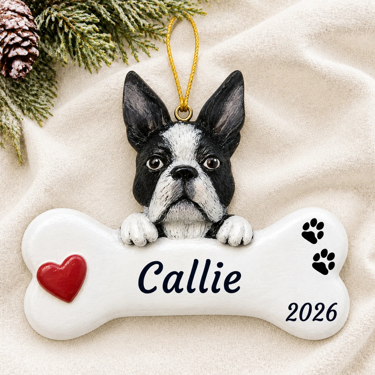 Personalized Boston Terrier Dog Bone christmas ornament laid on a soft white knit blanket