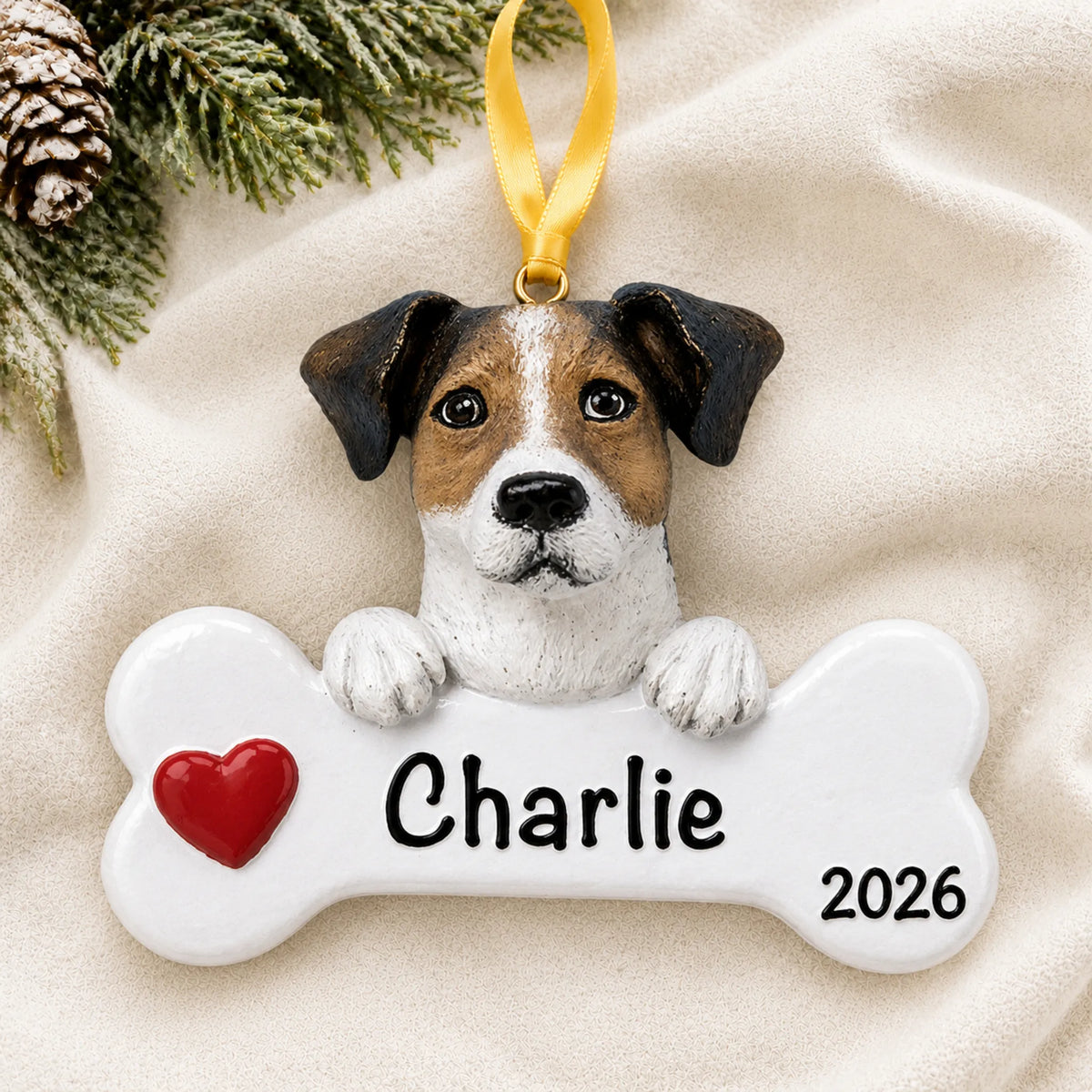 Personalized Jack Russell dog bone Christmas ornament resting on a soft white blanket with pine and pinecones