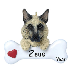 Personalized German Shepherd Christmas ornament, the dog resting its head and paws on a white dog bone with a red heart, the pet name laser engraved across the bone and the year below it