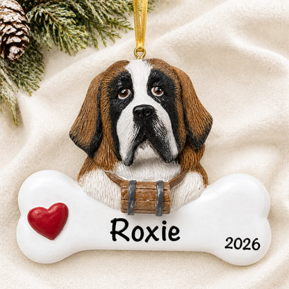 Personalized St. Bernard dog bone Christmas ornament resting on a soft white blanket with pine and pinecones