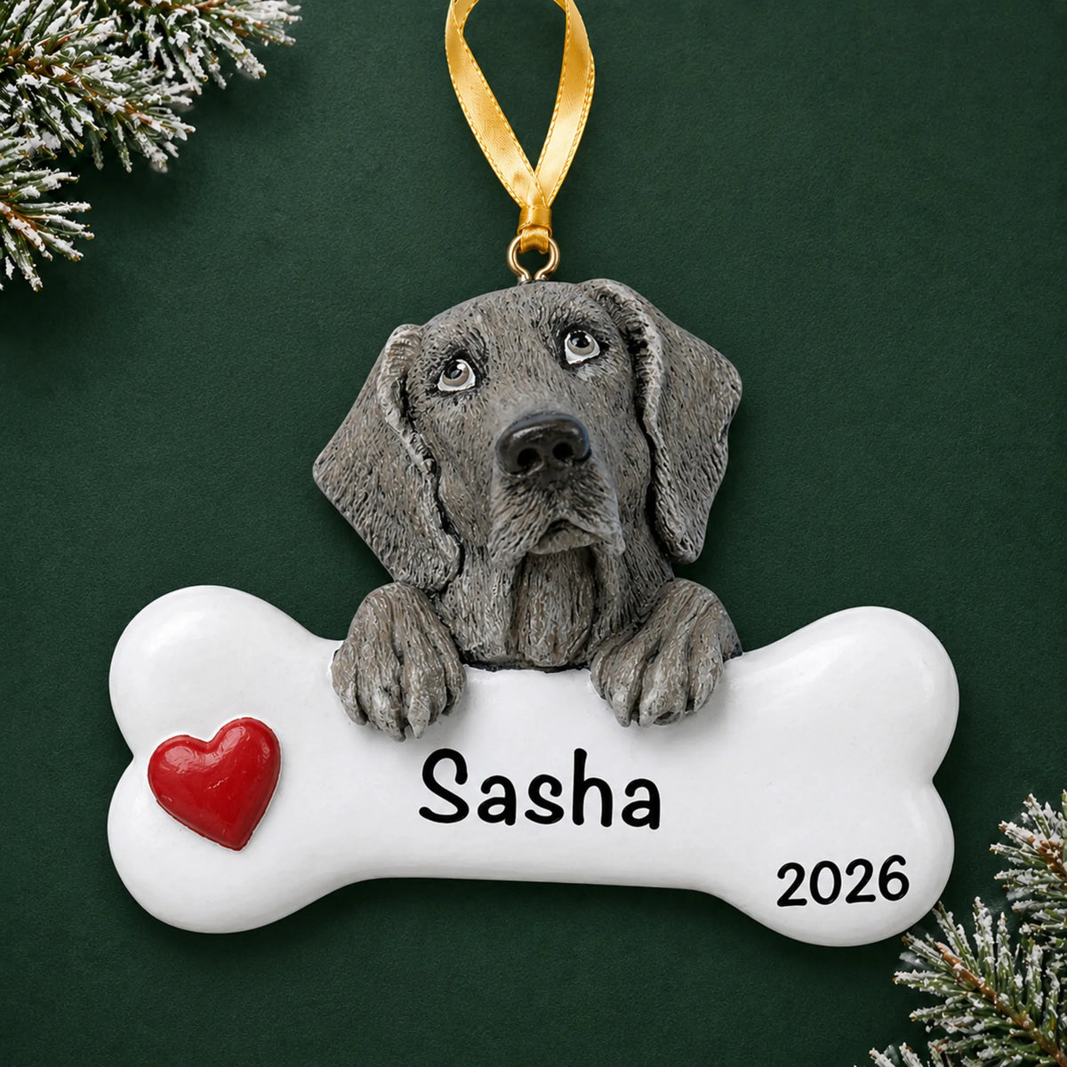 Personalized Weimaraner dog bone Christmas ornament, engraved with a name and year, on a green holiday backdrop