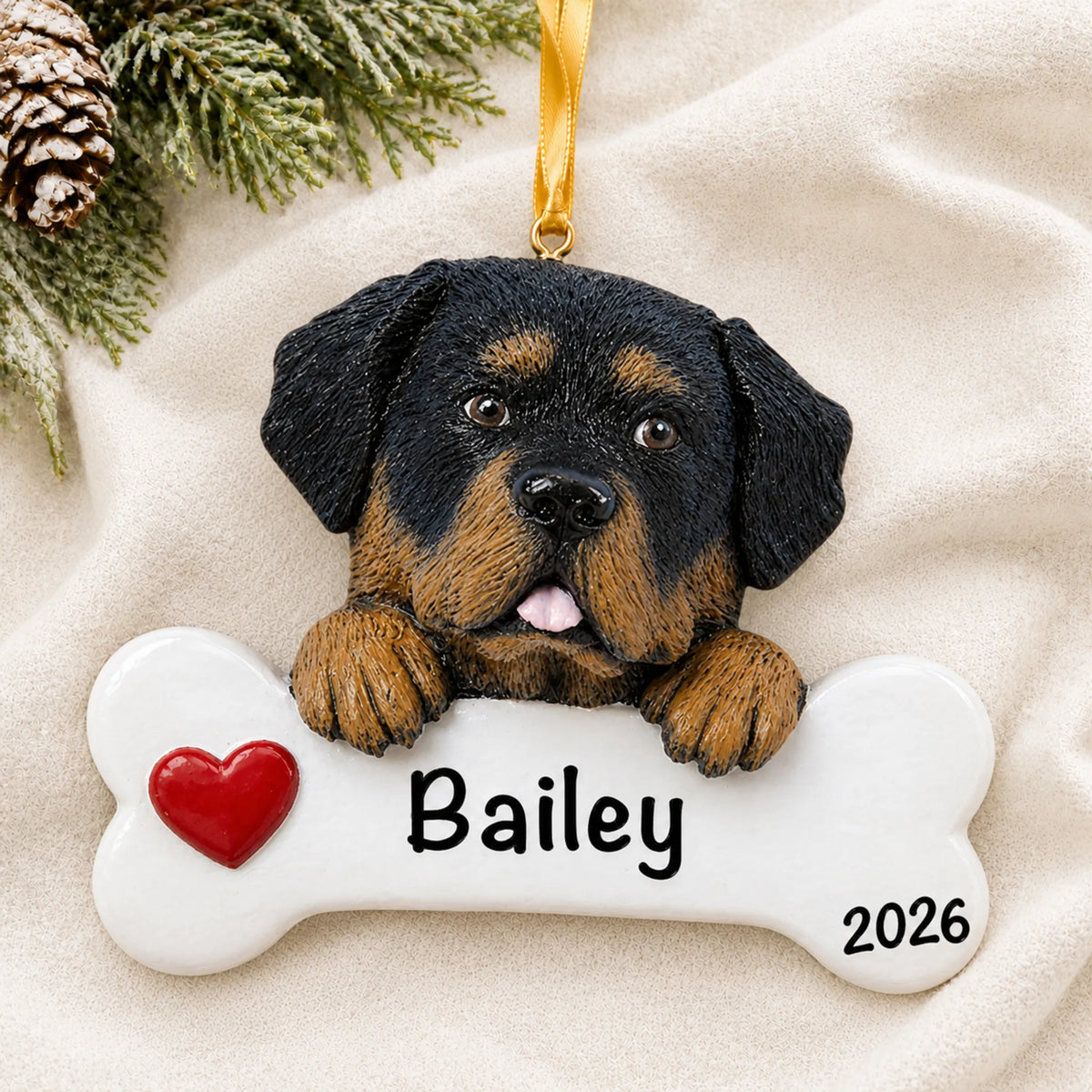 Personalized Rottweiler dog bone Christmas ornament resting on a soft white blanket with pine and pinecones