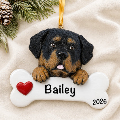 Personalized Rottweiler dog bone Christmas ornament resting on a soft white blanket with pine and pinecones