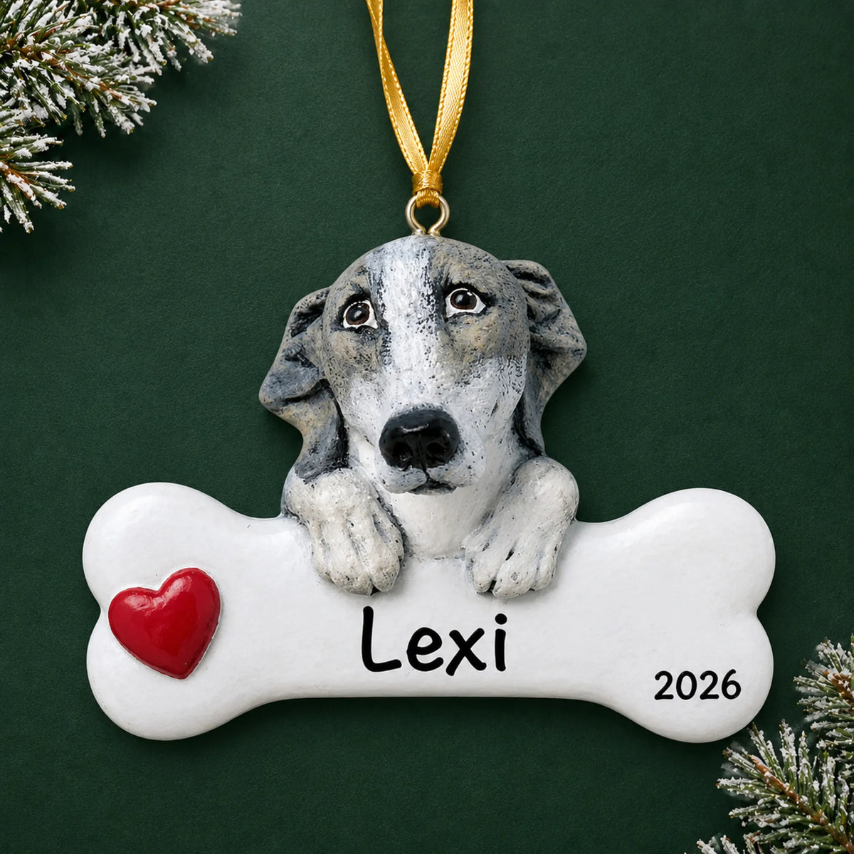 Personalized greyhound dog bone Christmas ornament, engraved with a name and year, on a green holiday backdrop